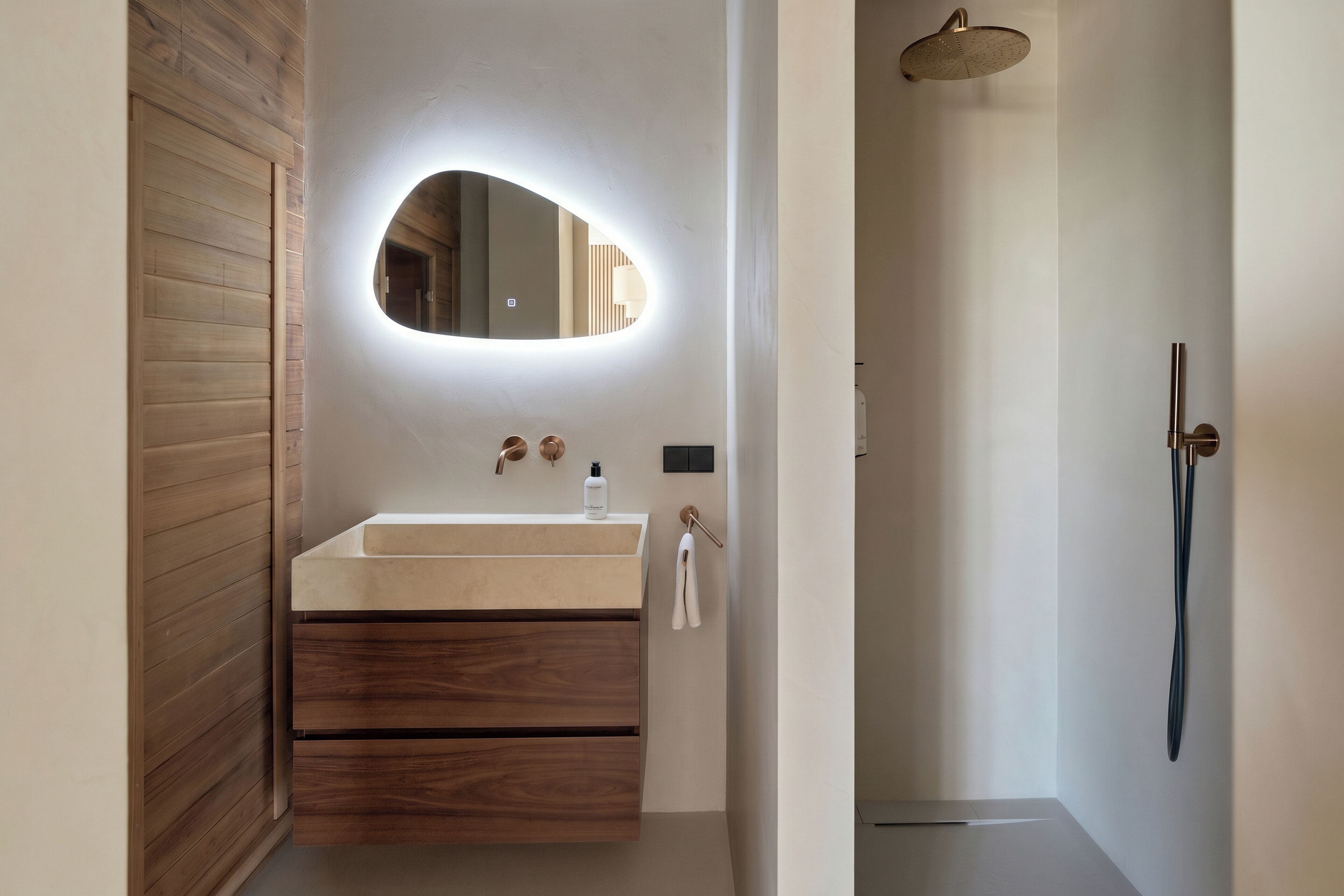 A modern bathroom with a wooden vanity, a round mirror, a handheld showerhead, and a towel rack.