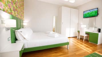 Une chambre d’hôtel comprenant un lit, un bureau, une chaise, une télévision et une armoire.