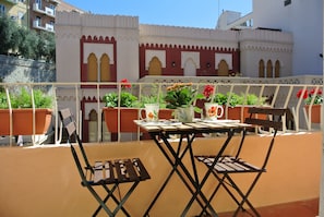 A balcony with a table, chairs, and potted plants. - B&B Pellicano Guest House (Reggio Calabria)