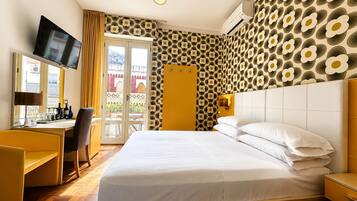 Une chambre d’hôtel avec un lit, un bureau, une chaise, une télévision et un balcon avec vue.