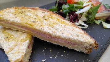 A sandwich on a slate plate with a side salad.