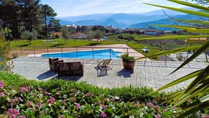 Uma área de piscina com vista para uma aldeia e montanhas.