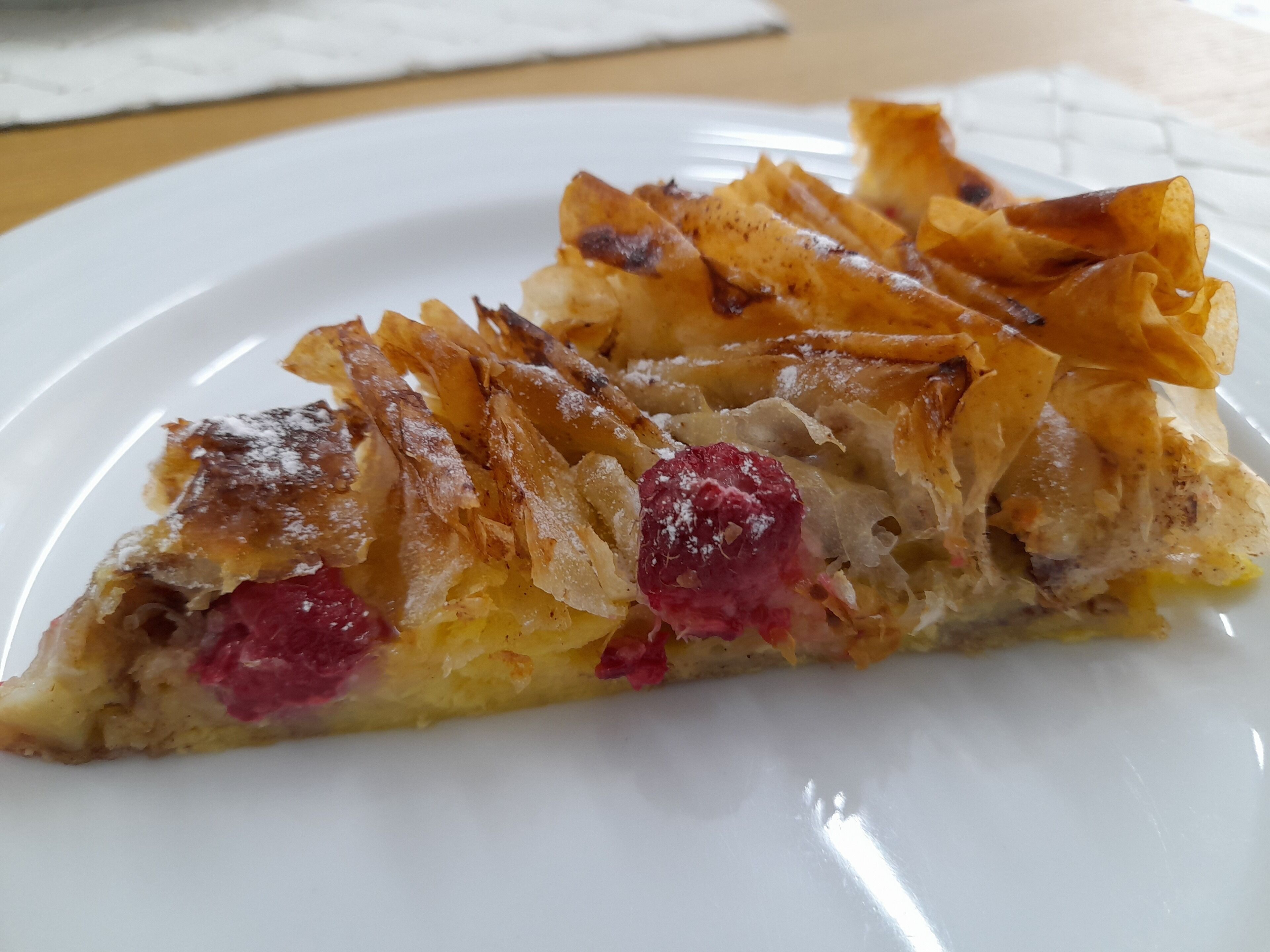 A slice of fruit tart on a white plate.