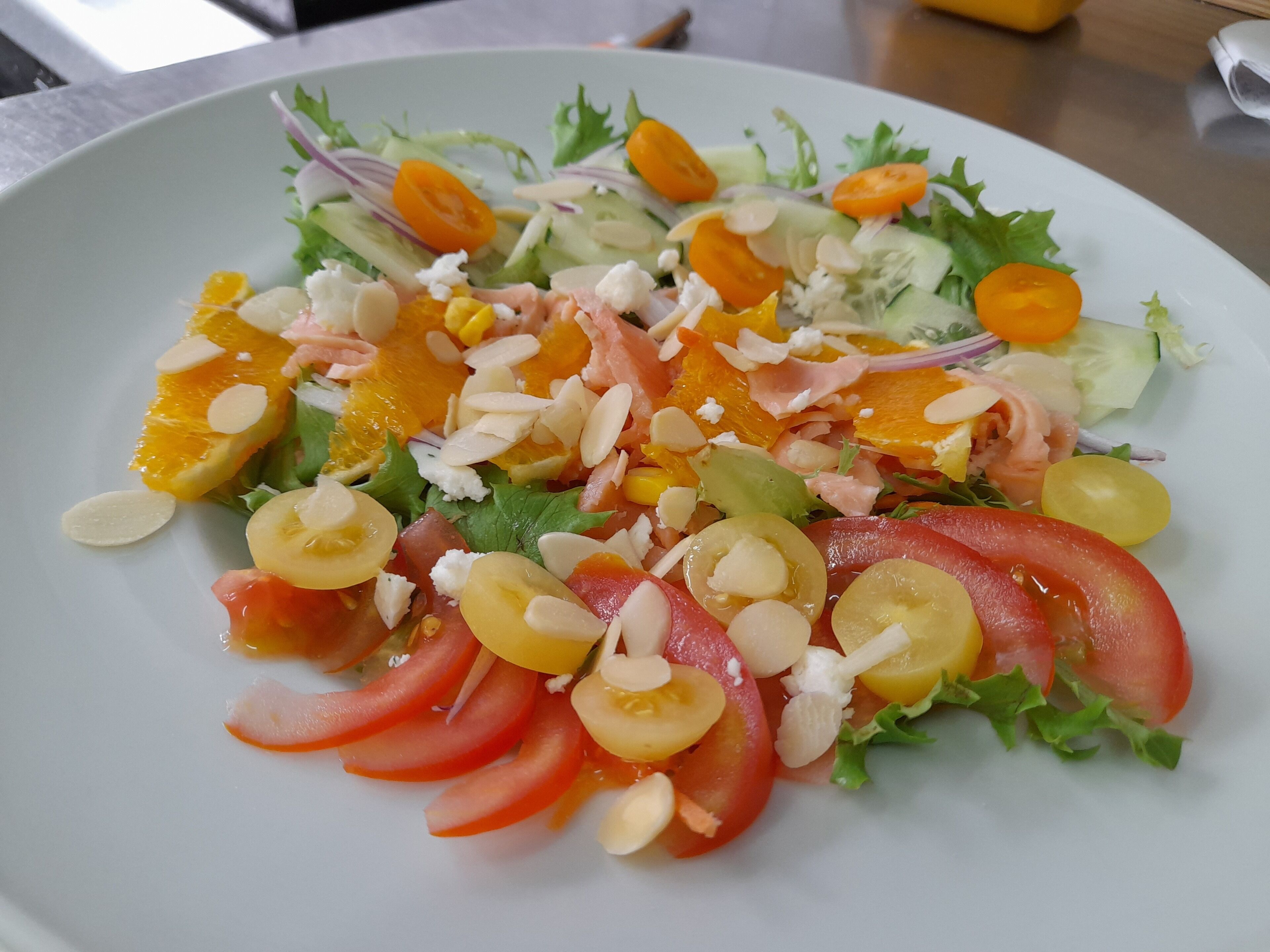 Un plato de ensalada mixta con diversas verduras y frutos secos.