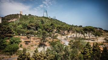 Een glooiend landschap met een opvallende toren en een modern gebouw.