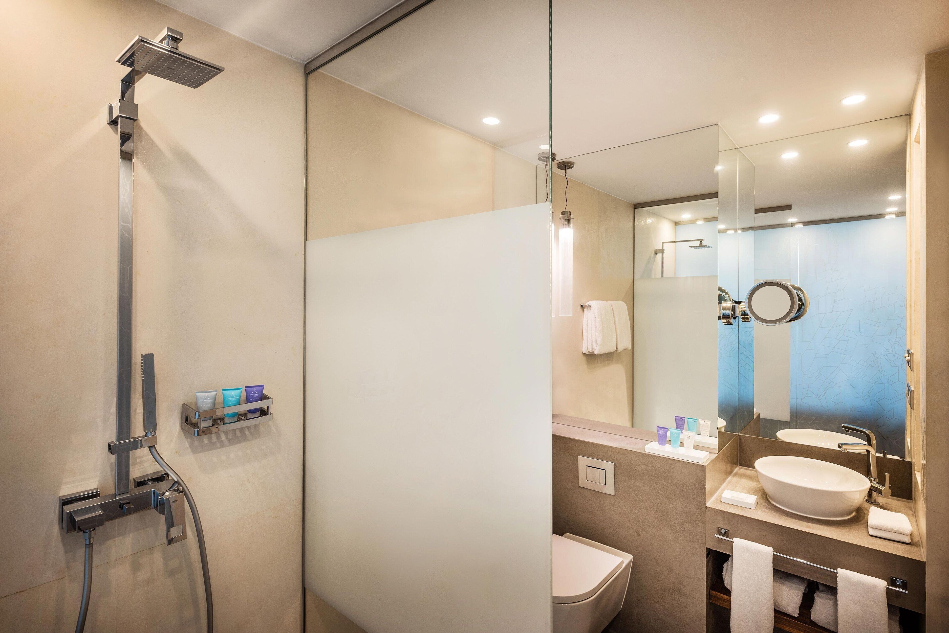Une salle de bain moderne équipée d’une douche, de toilettes et d’un lavabo.