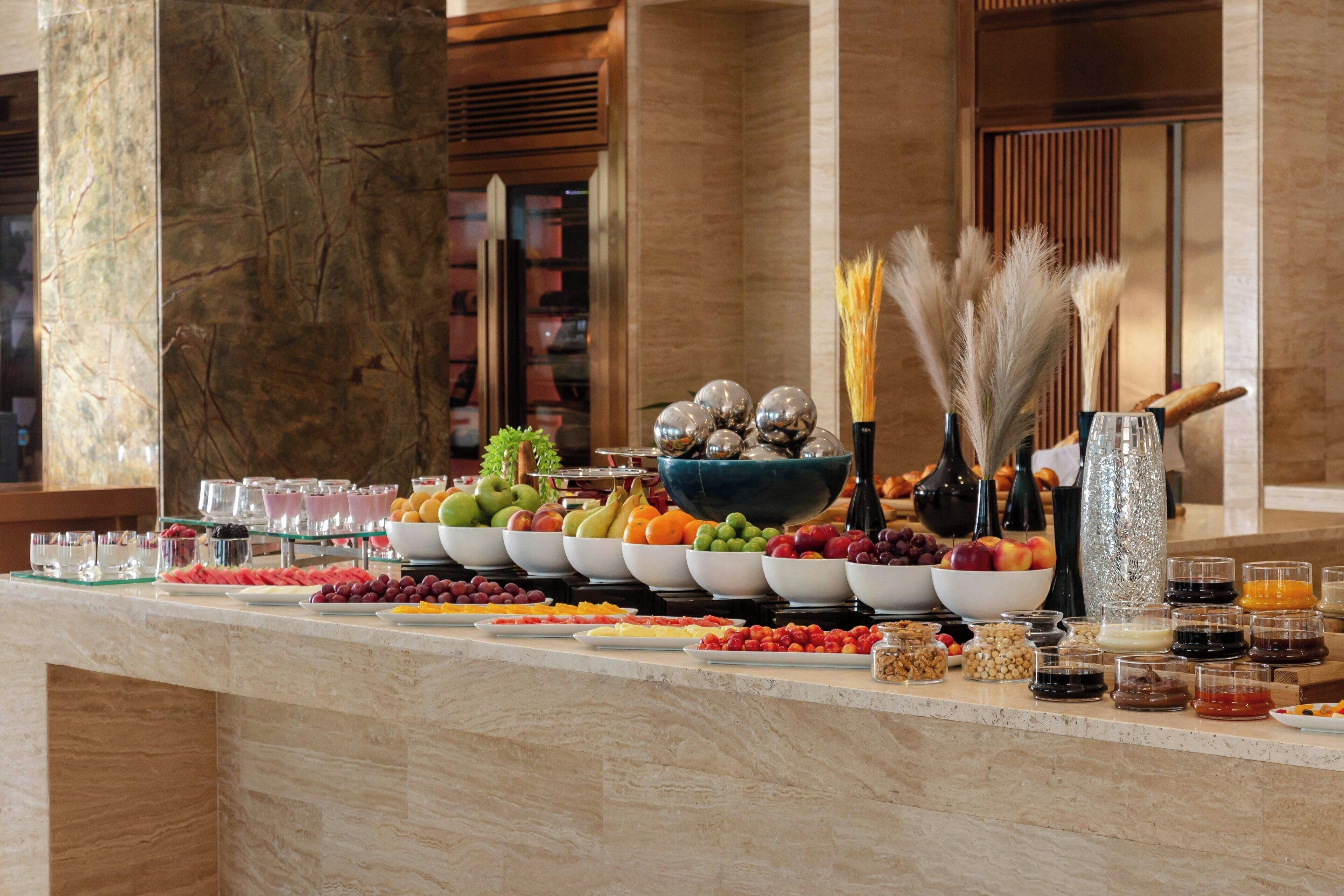 Un buffet proposant une variété de fruits, de fromages et de boissons.