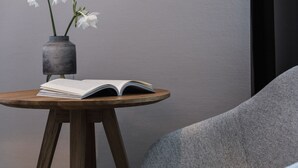 Una mesa redonda de madera con un libro abierto y un jarrón con flores blancas.