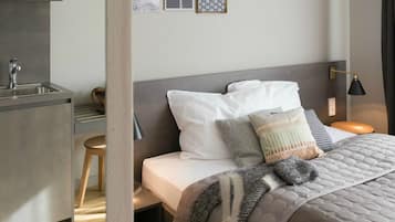 Ein modernes Schlafzimmer mit Bett, Nachttisch und kleinem Schreibtisch mit Stuhl.