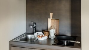Una cocina moderna con un lavamanos de acero inoxidable, una estufa y una tabla de cortar de madera.