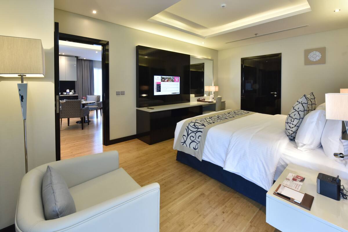 Une chambre d’hôtel moderne équipée d’un grand lit, d’un bureau, d’une chaise et d’un téléviseur.