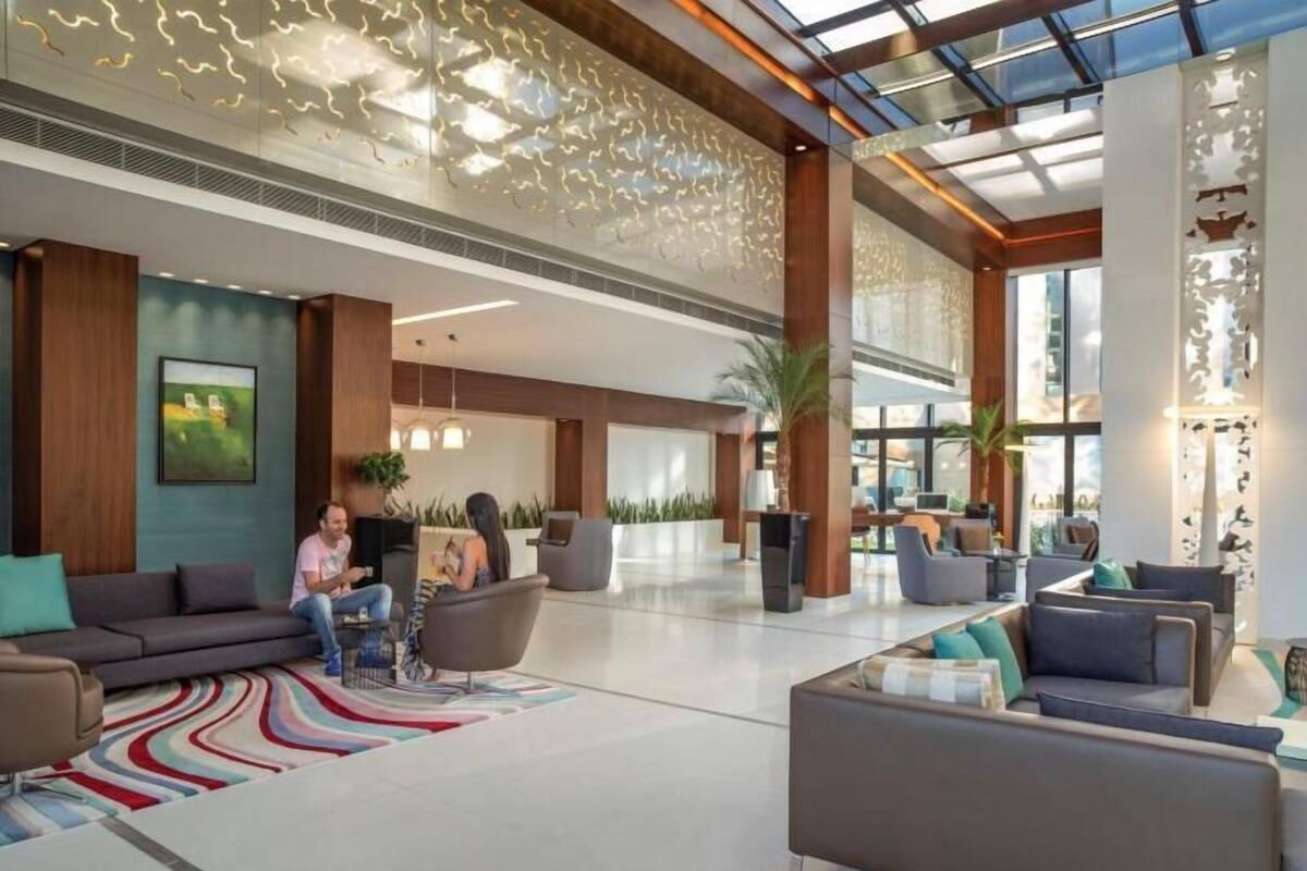 En rummelig lobby med moderne møbler, et stort vindue og et dekorativt loft.