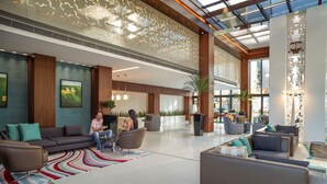 A spacious lobby with modern furniture, a large window, and a decorative ceiling. - Tango Arjaan by Rotana Istanbul (Istanbul)