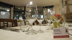 Une table à manger avec plusieurs verres à vin et une enseigne indiquant le nom et l’adresse du restaurant.