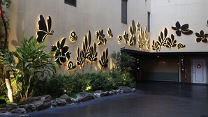 A building facade with decorative wall art and a closed garage door. - Lanxia Boutique Motel (Taichung)