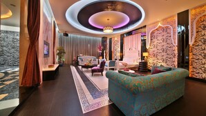 A modern hotel lobby with a central seating area, a patterned wall, and a ceiling with a circular design. - Lanxia Boutique Motel (Taichung)