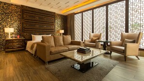 A modern living room with a sofa, armchairs, a coffee table, and a decorative wall with a geometric pattern. - Lanxia Boutique Motel (Taichung)