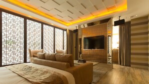 A modern bedroom with a large bed, a sofa, a TV, and a wooden floor. - Lanxia Boutique Motel (Taichung)