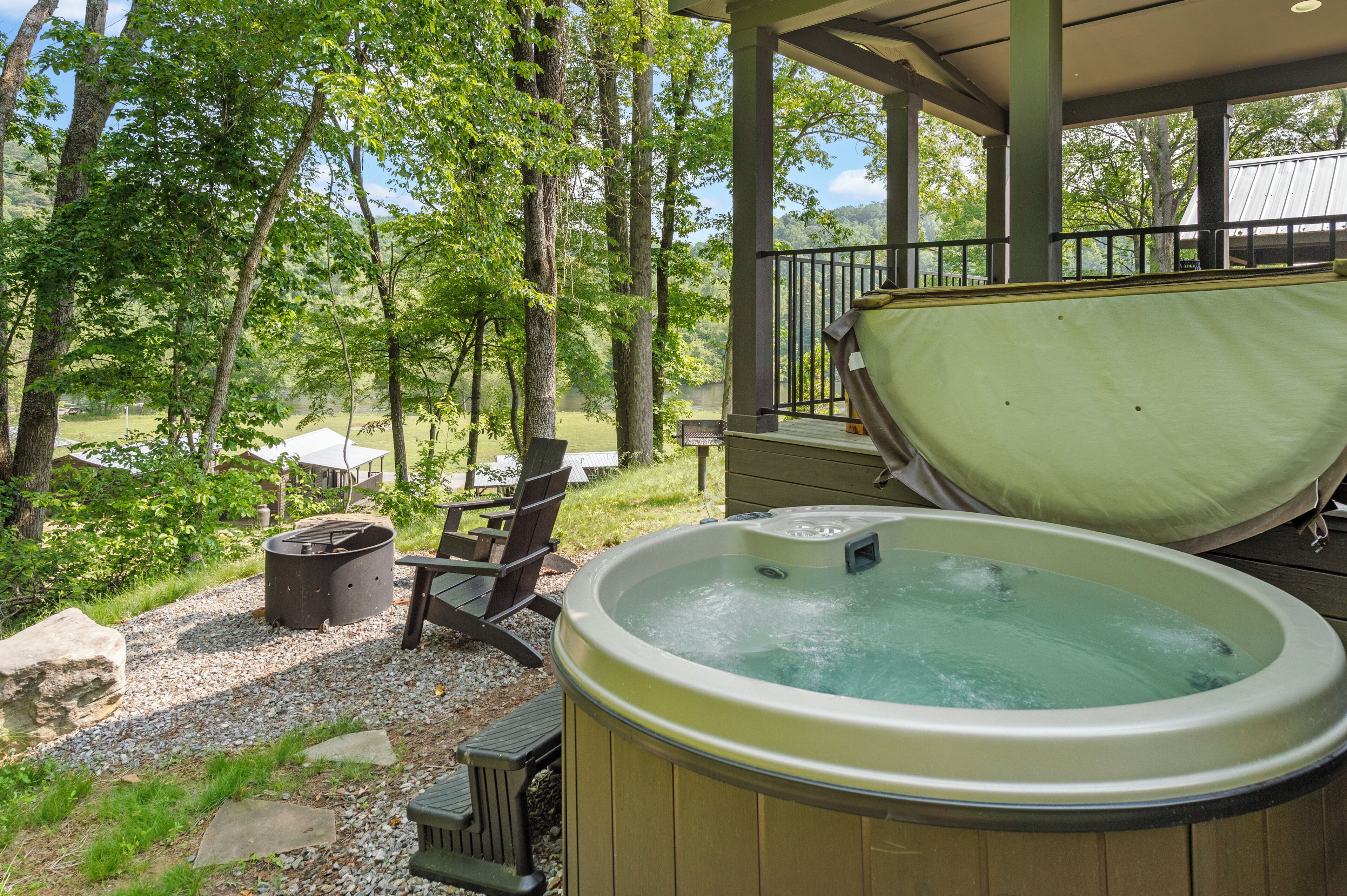 Un bain à remous avec une terrasse en bois et une vue sur une zone boisée.