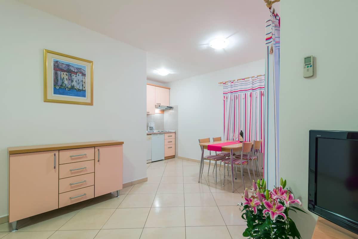 Una cocina moderna con comedor, televisor y un cuadro en la pared.