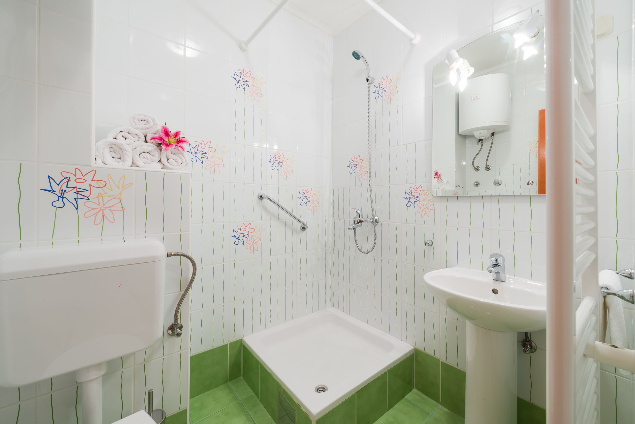 Ein Badezimmer mit Dusche, Waschbecken und Toilette.