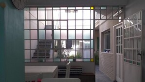 A room with a large window, a white table, and a chair. - Boho Rooms (Buenos Aires)