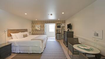 Une chambre à coucher comprenant un lit, une table de chevet, une commode et une petite table à manger avec un plateau.
