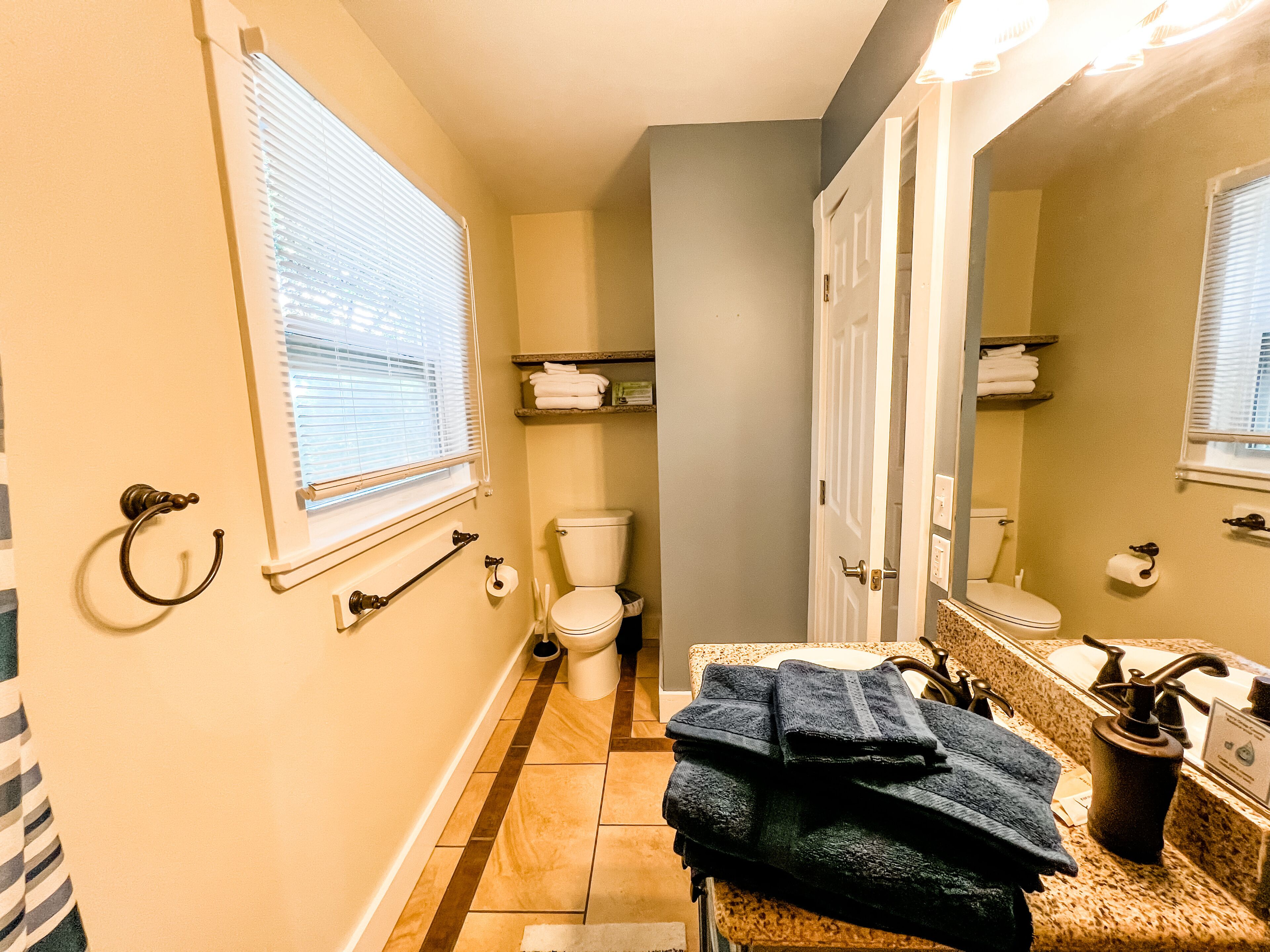 A bathroom with a toilet, sink, and towel rack.
