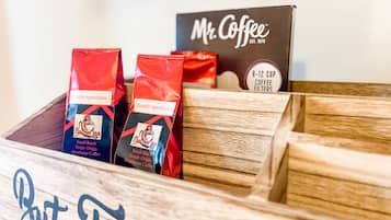 Uma caixa de madeira com sacos de café rotulados 'Zombie Apocalypse' e uma caixa de 'Mr. Coffee'.