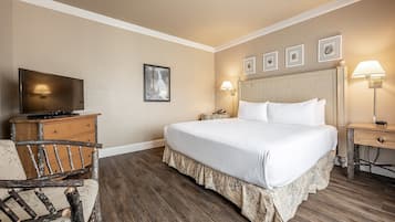 Ett hotellrum med en säng, en tv, ett skrivbord och en stol.