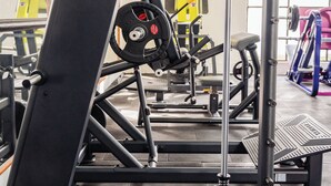 A gym with various exercise equipment, including a squat rack and weight benches. - Hotel Azucena (Huamantla)