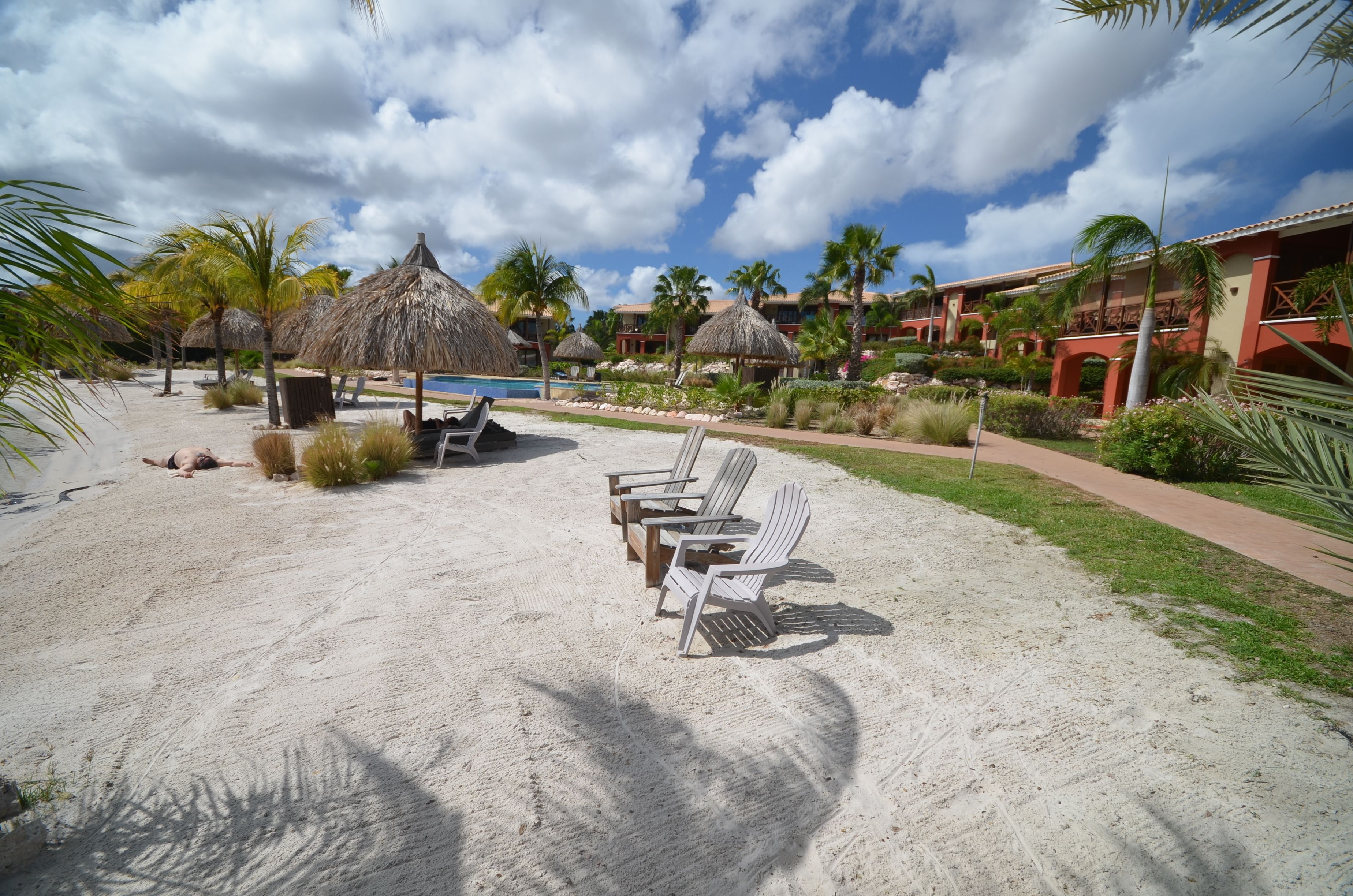Privat strand, hvit sand, solsenger og parasoller