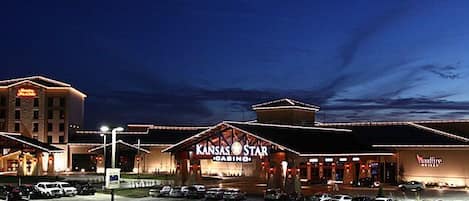 Un gran hotel con varias edificaciones, un letrero llamativo que dice 'Kansas Star', y un estacionamiento con varios automóviles.