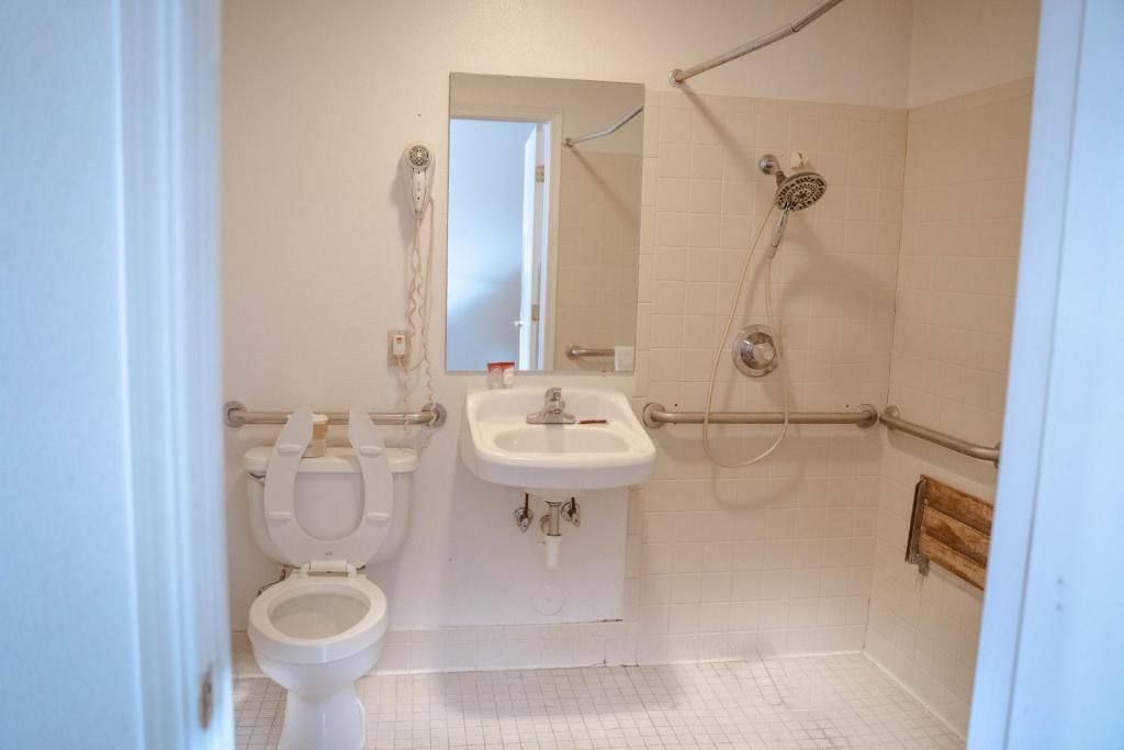A bathroom with a toilet, sink, and shower.
