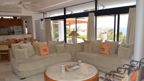 Una sala de estar con dos sofás, una mesa de centro y un comedor con una mesa y sillas.