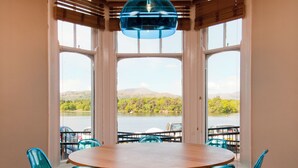 A round table with four blue chairs, a wooden table top, and a blue pendant light. - YHA Ambleside - Hostel (Ambleside)