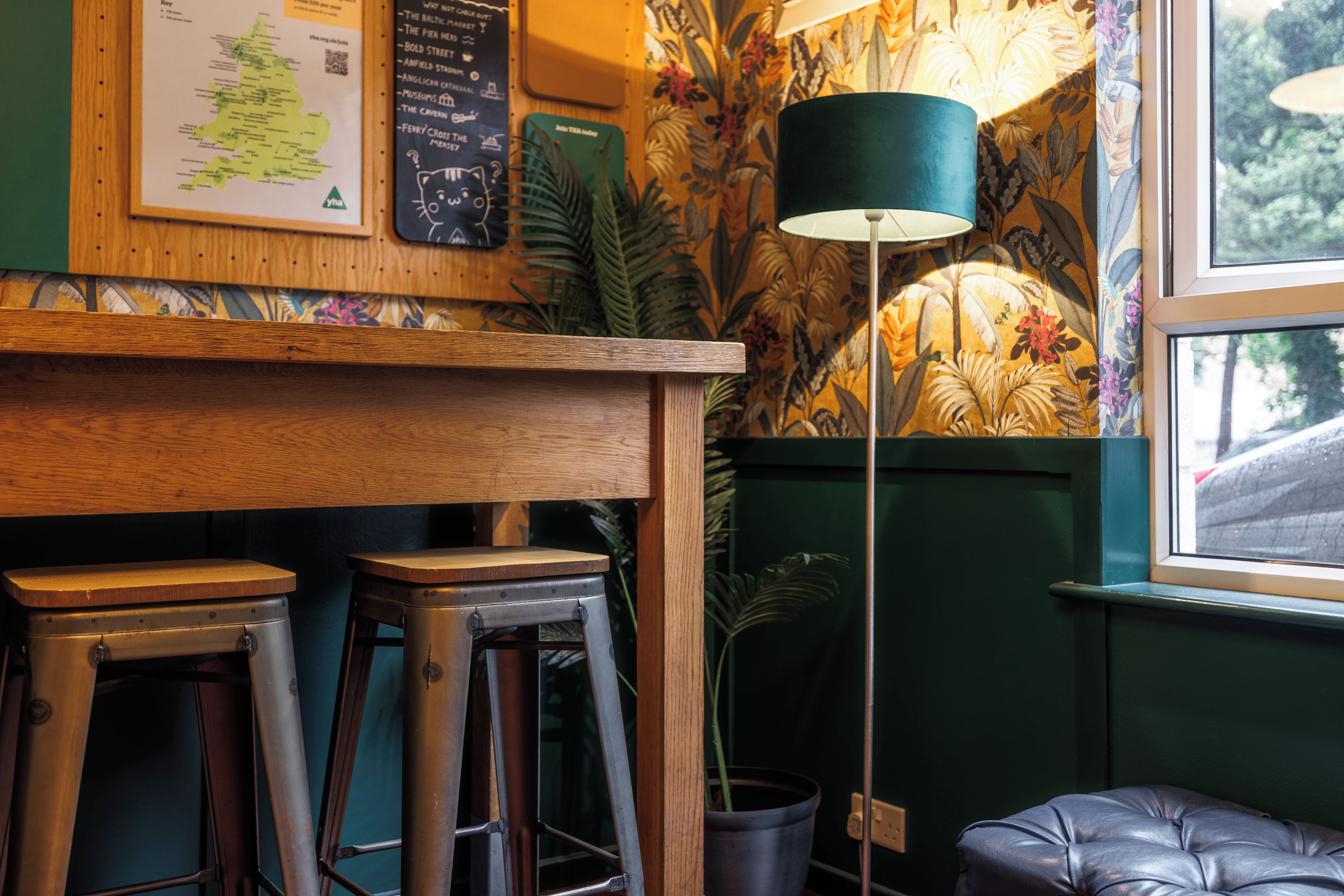 A bar area with stools, a map on the wall, and a lamp.