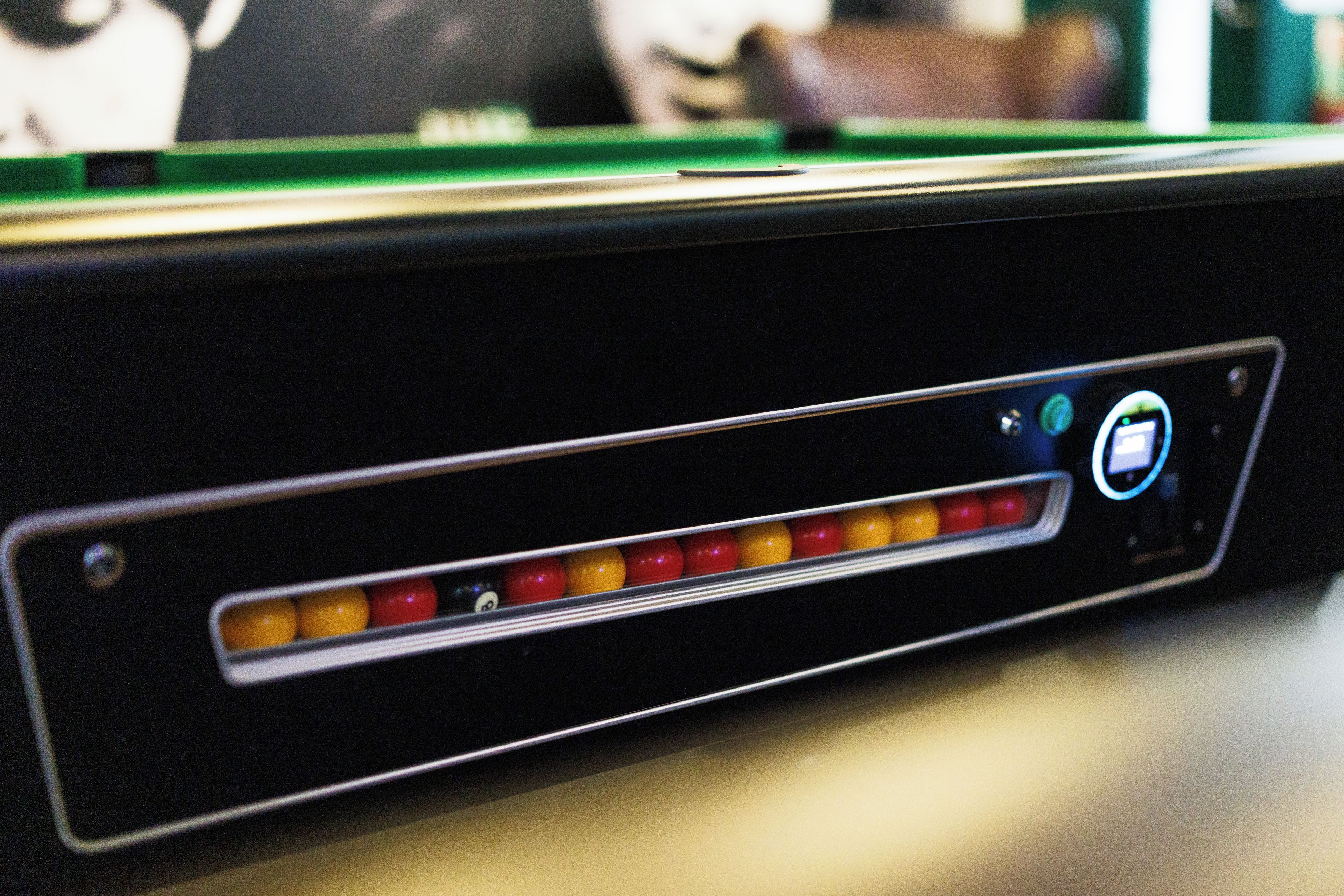 A close-up of a pool table with a cue stick and balls.