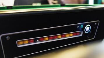 A close-up of a pool table with a cue stick and balls.