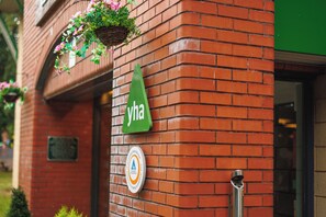 A brick building with a hanging flower basket and a green sign with the letters 'yha'. - YHA Liverpool Albert Dock - Hostel (Liverpool)