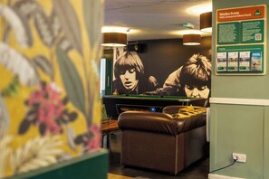 A billiards table in a room with a mural and a poster on the wall. - YHA Liverpool Albert Dock - Hostel (Liverpool)