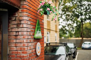 A brick wall with a hanging flower basket and a green sign with the letters 'yha'. - YHA Liverpool Albert Dock - Hostel (Liverpool)