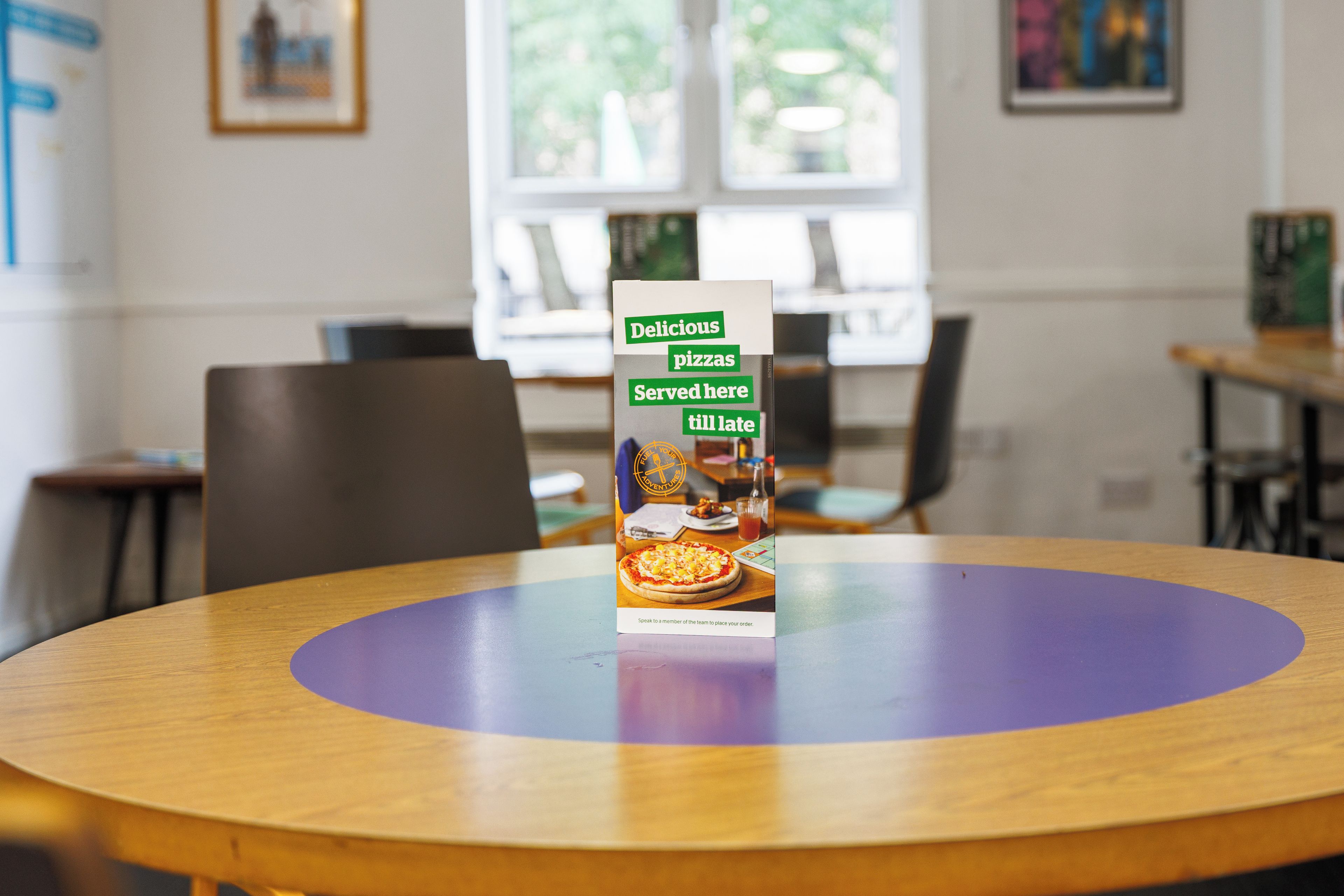 A brochure on a table in a room with a window and chairs.
