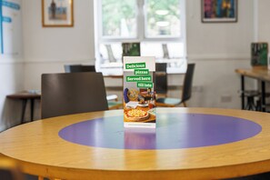 A brochure on a table in a room with a window and chairs. - YHA Liverpool Albert Dock - Hostel (Liverpool)