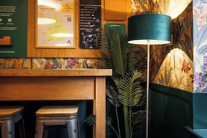 A wooden counter with stools, a map, and a lamp. - YHA Liverpool Albert Dock - Hostel (Liverpool)