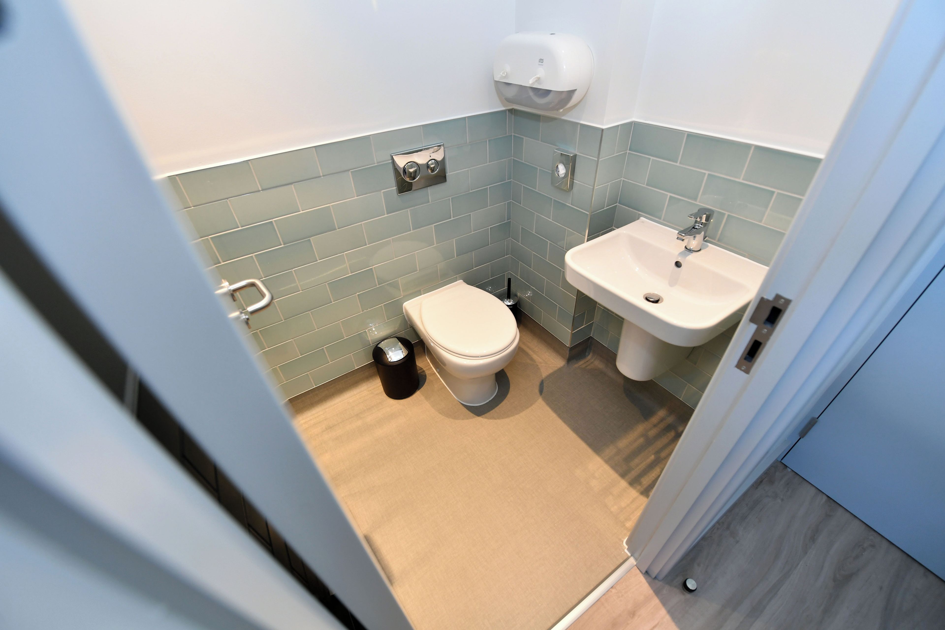 Ein kleines Badezimmer mit Toilette, Waschbecken und Mülleimer.