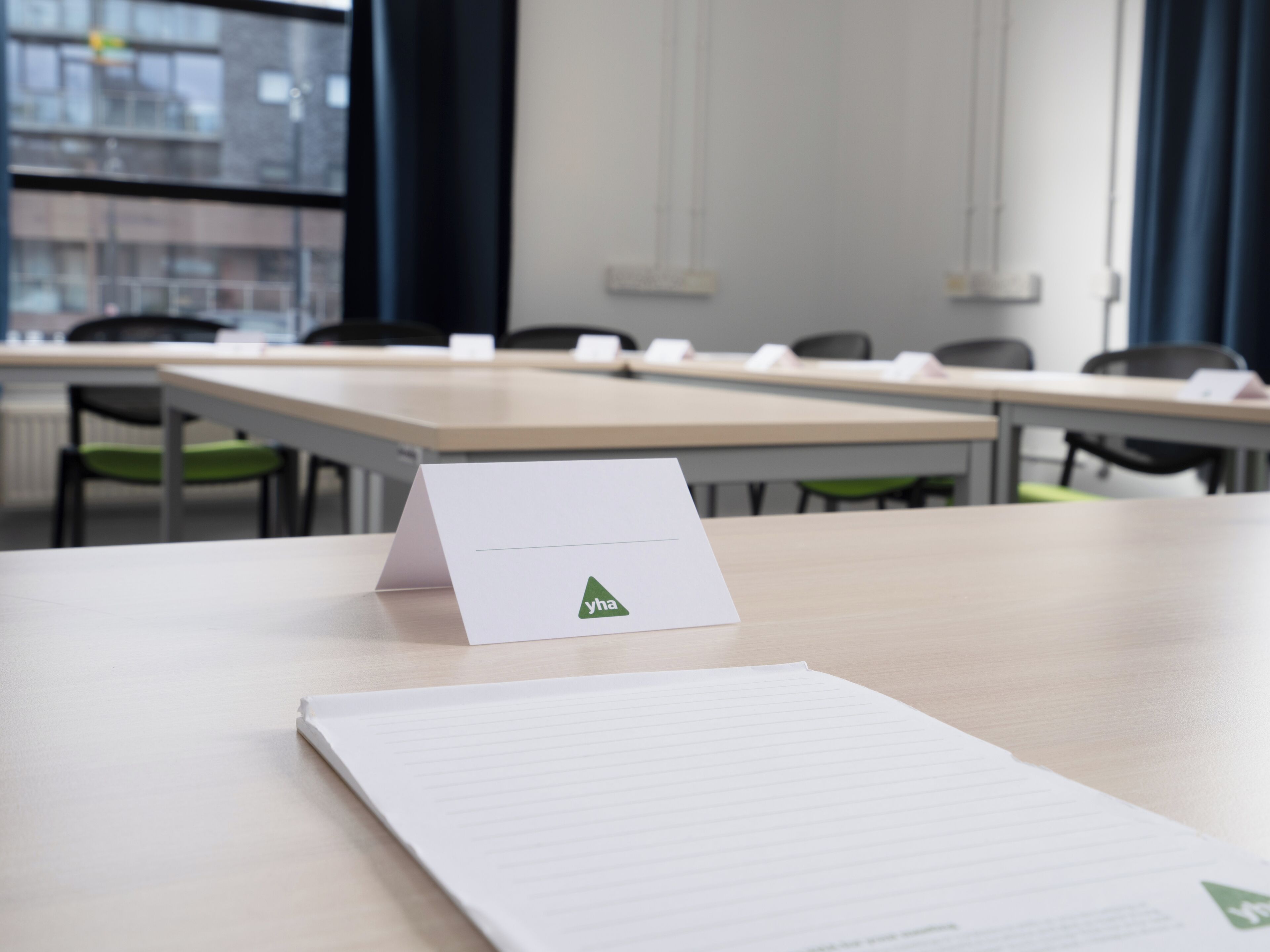 A conference room with a table, chairs, and a sign with the logo "yha".