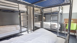 A bunk bed room with a blue ceiling, a green chair, and a small table. - YHA Manchester - Hostel (Manchester)