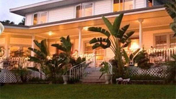 A two-story house with a covered porch, large windows, and a staircase leading to the upper floor. - Ka'awaloa Plantation Bed & Breakfast (Captain Cook)