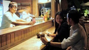 A bar setting with wooden counters and a bartender. - Omah Sinten Heritage Hotel & Resto (Surakarta)